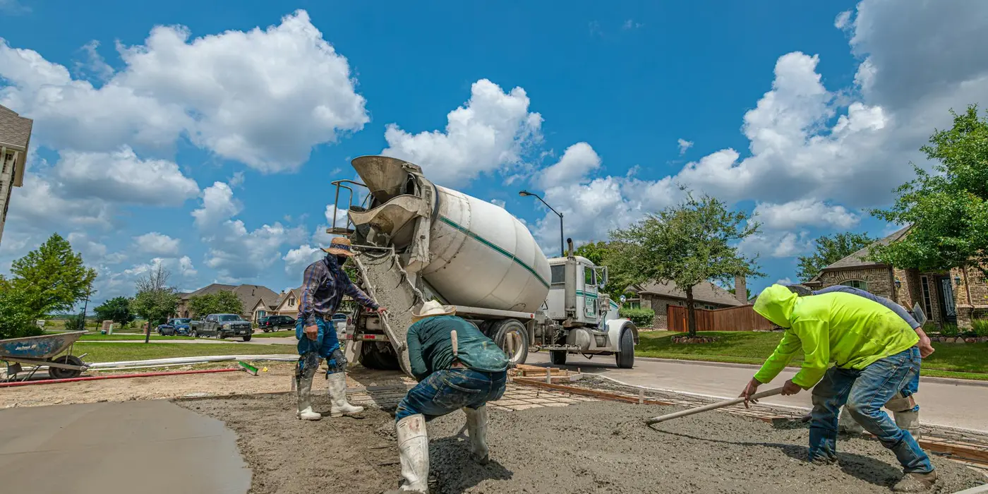 concrete workers pouring concrete and spreading it for a new foundation from Leander Stamped Concrete in Round Rock, TX - Round Rock TX